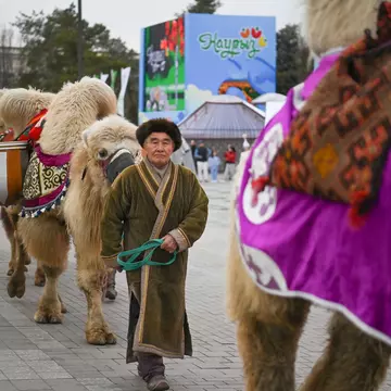 A man leads a camel as part of a Nauryz celebration, Almaty, Kazakhstan