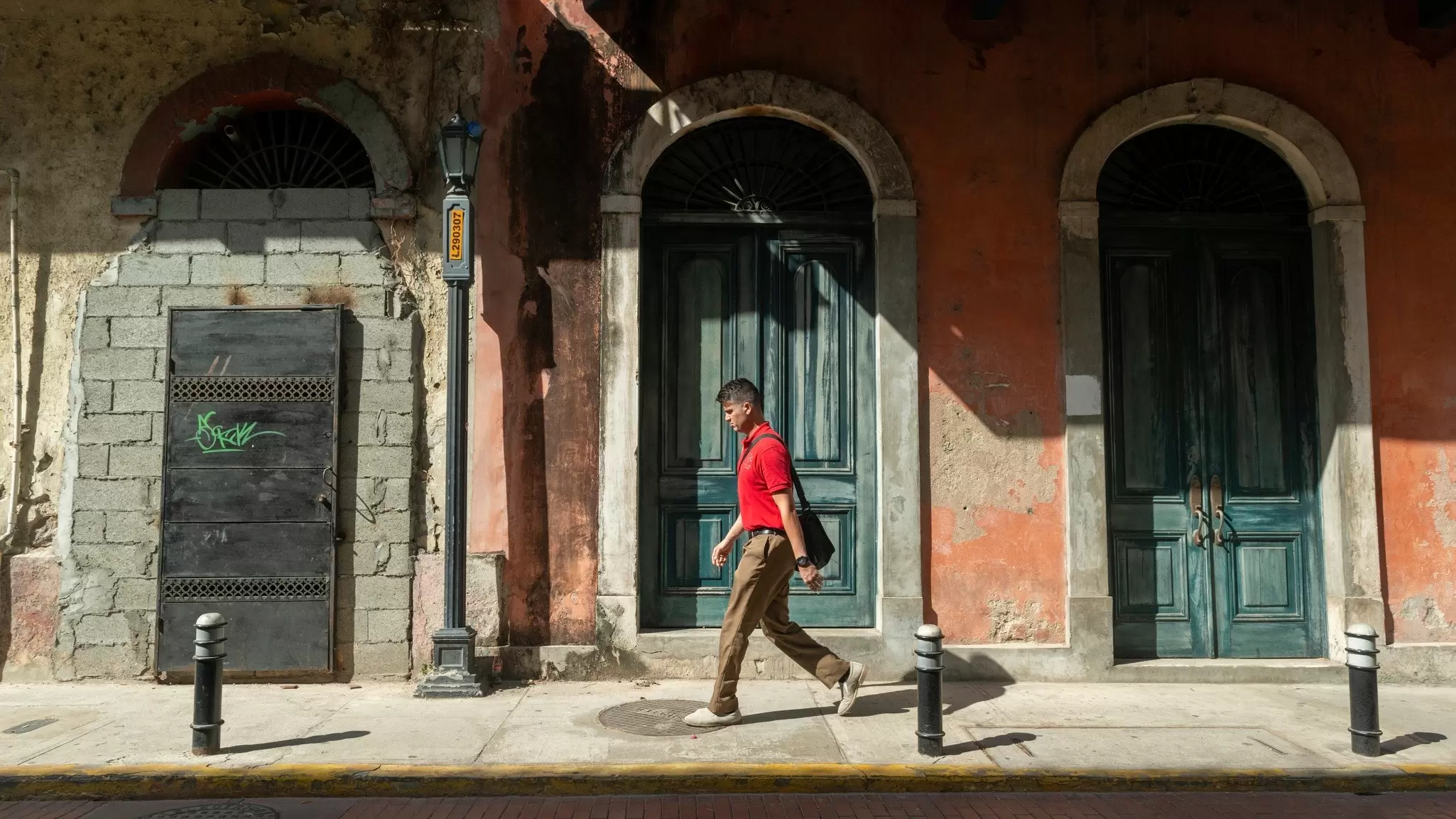 A man walks past historic buildings in various stages of refurbishment in Casco Viejo, Panama City. 