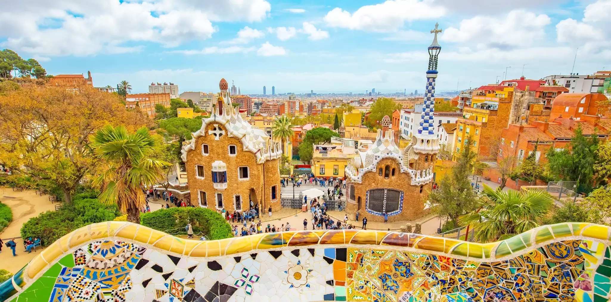 Park Guell's curving mosaic terrace bench above Gaudi's pavilions and the Barcelona skyline