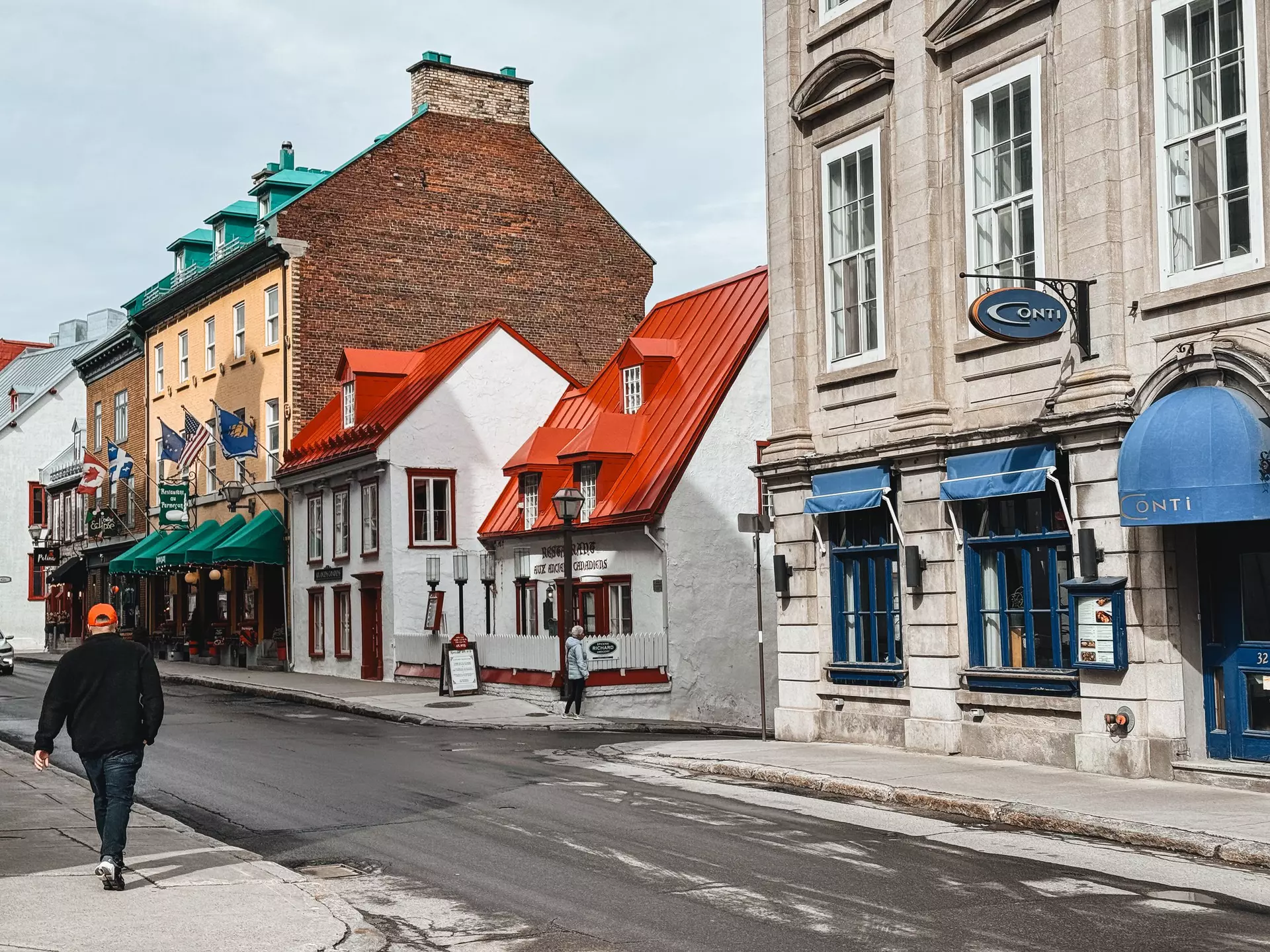 Aux Anciens Canadiens old-fashioned restaurant. A group of walkers are crossing the road to get to the restaurant.