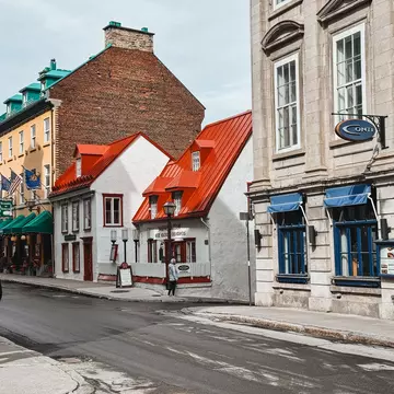 Aux Anciens Canadiens old-fashioned restaurant. A group of walkers are crossing the road to get to the restaurant.