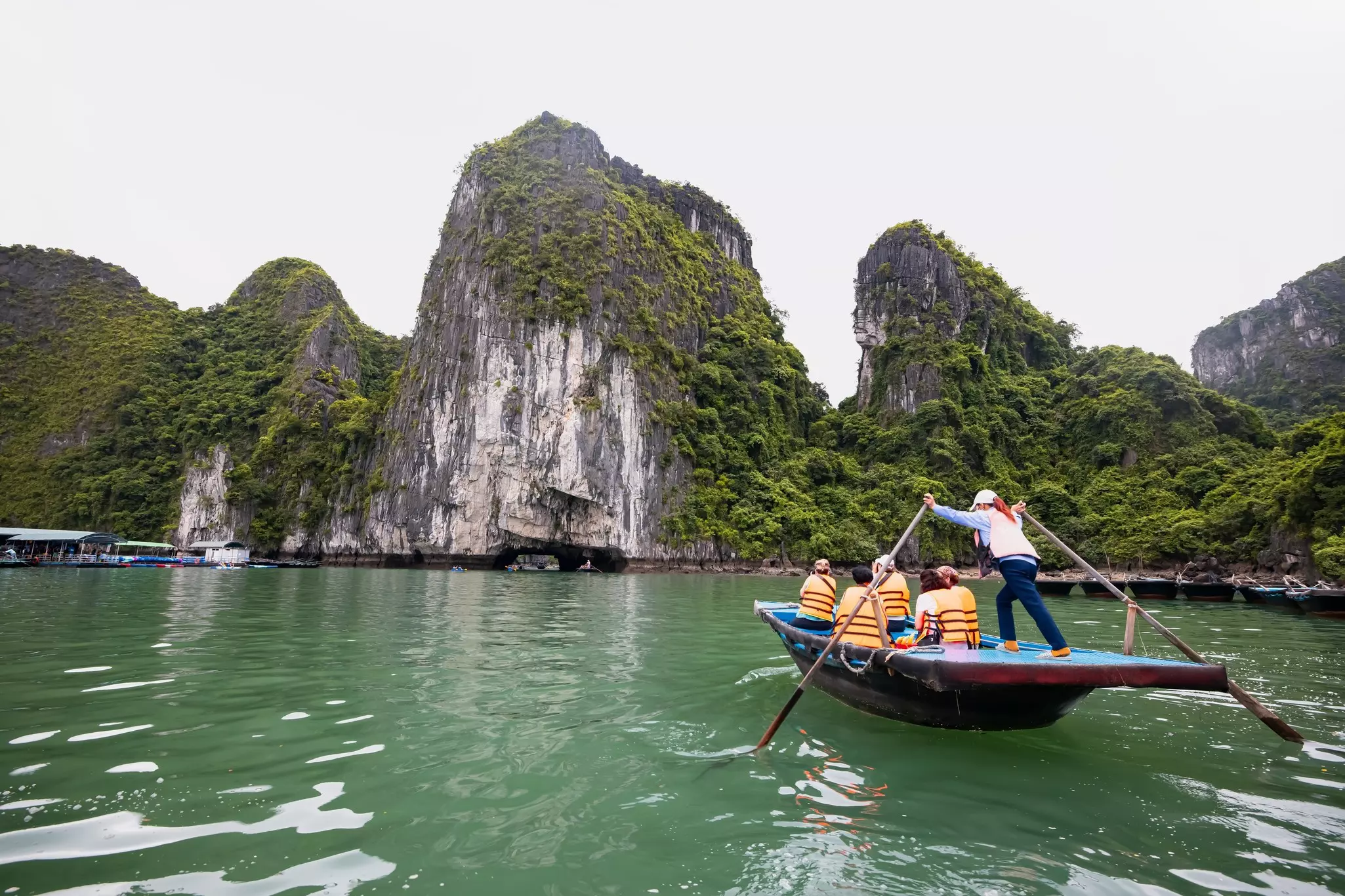 People in a boat on Halong Bay with one person rowing