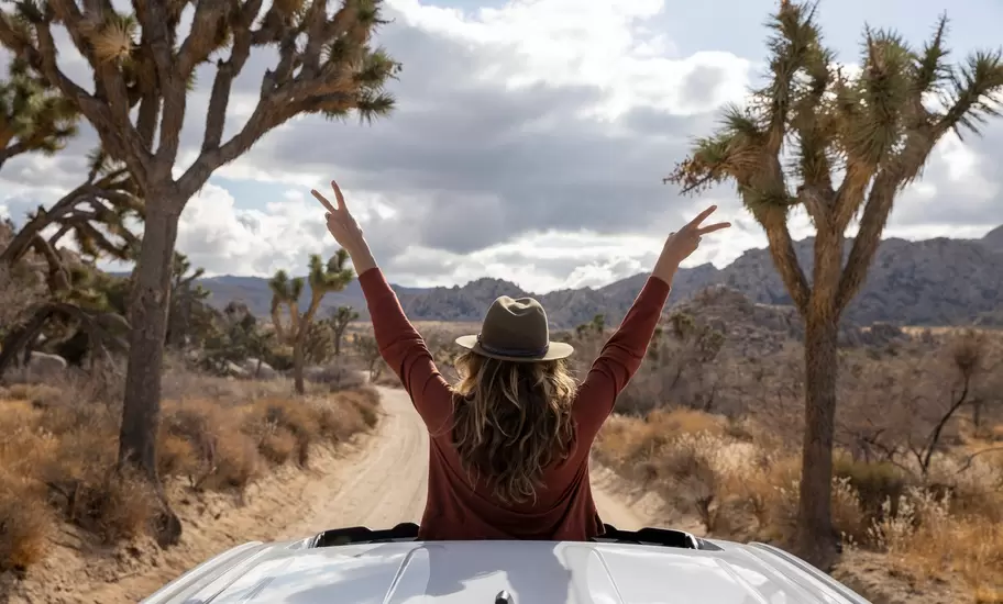 Woman standing in sunroom of car in Joshua Tree National Park
