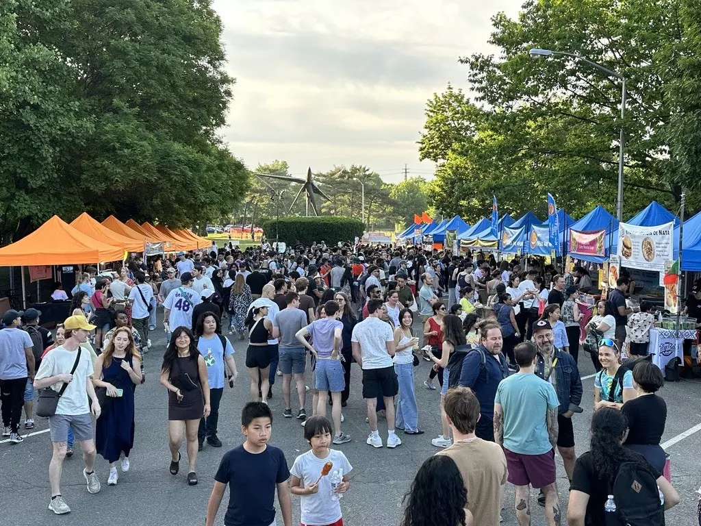 Crowd of people at an outdoor street market on an overcast day.