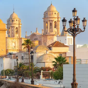 View of the Catedral de Cádiz from the waterfront at dawn in Spain.