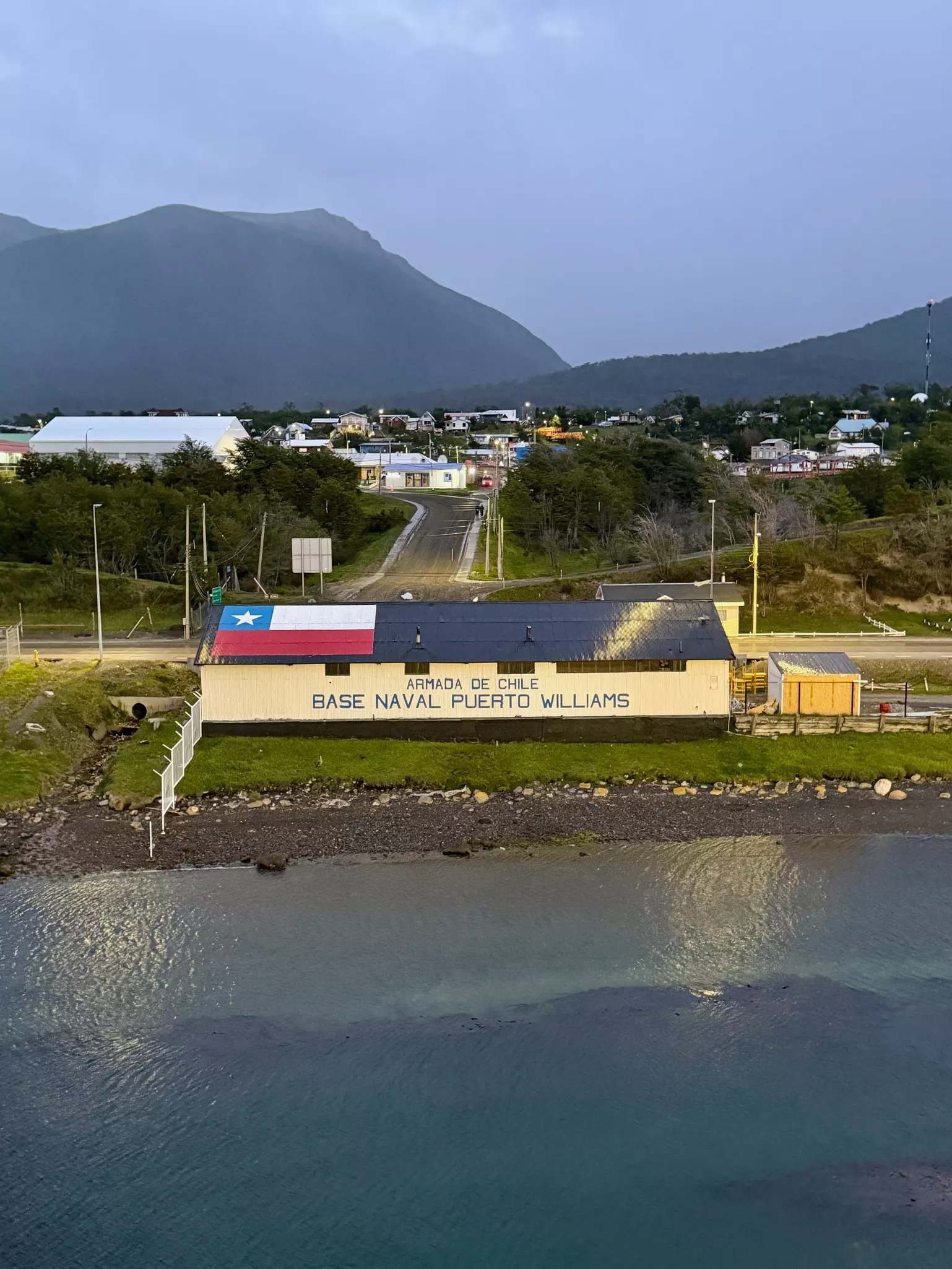A large building at the edge of the sea with a sign that reads "Armada de Chilem Base Naval Puerto Williams".