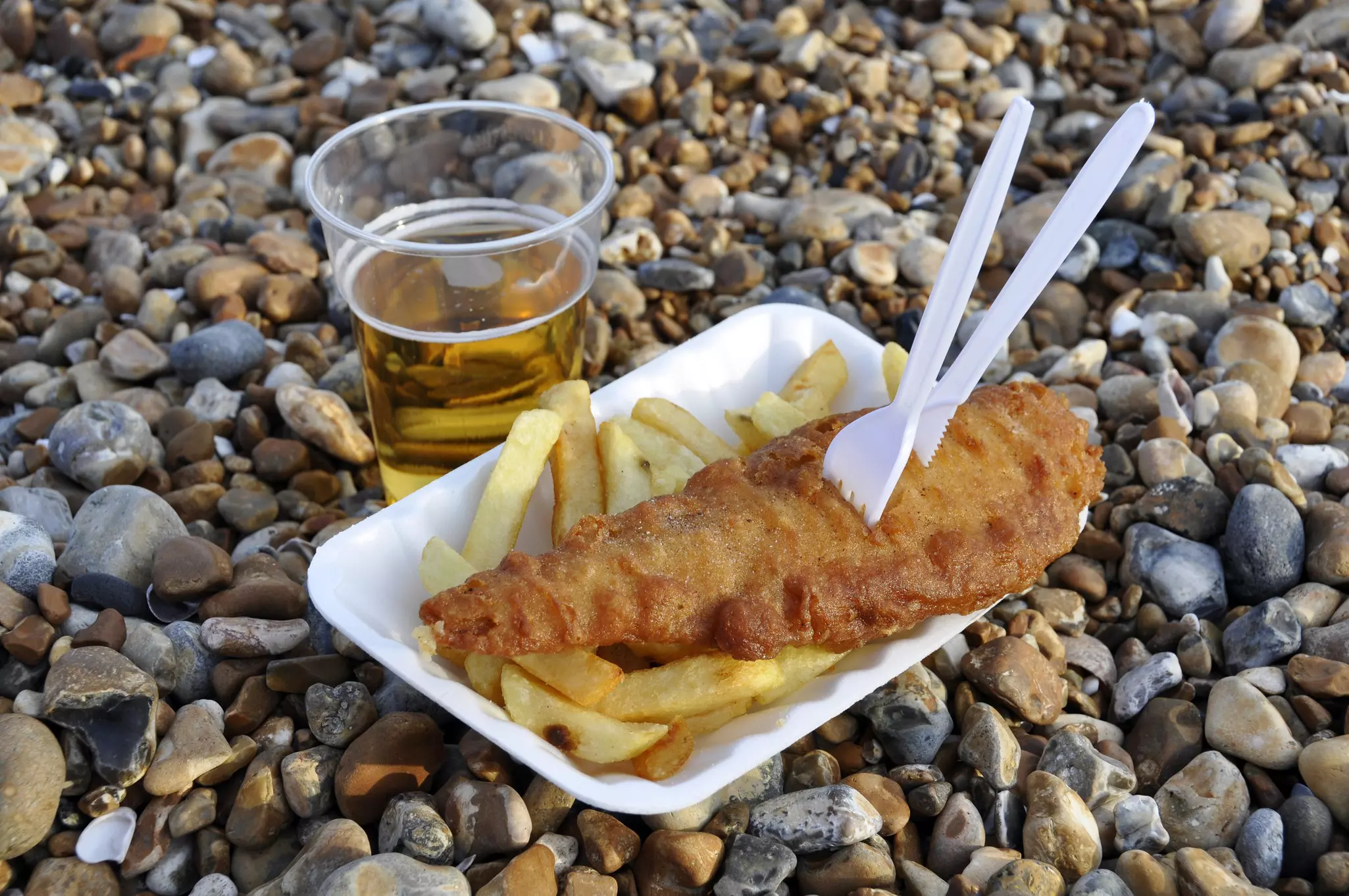 Fish and chips and a pint of beer on Brighton beach, England.