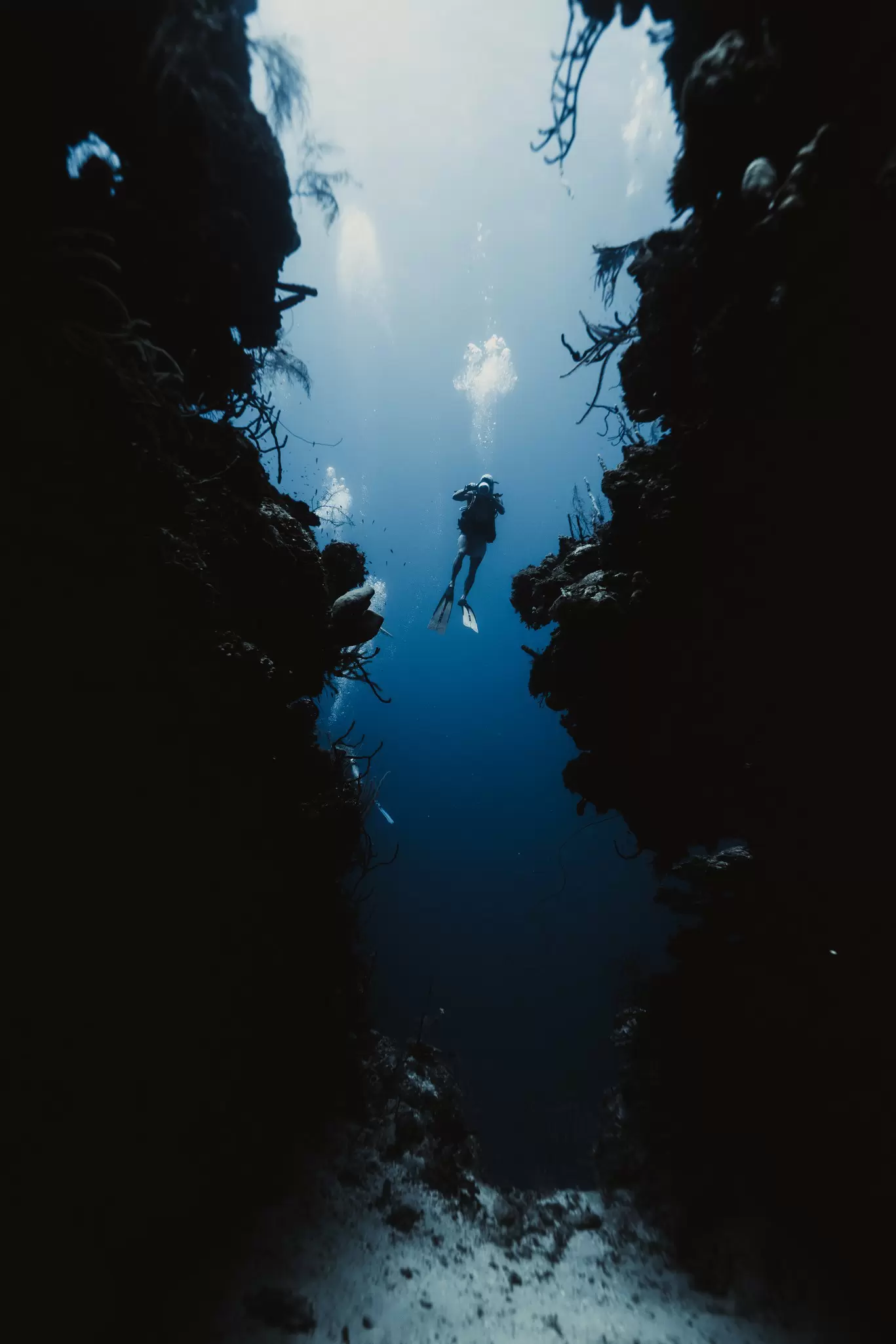 A solo scuba diver with excellent buoyancy hovers between walls in an underwater passage