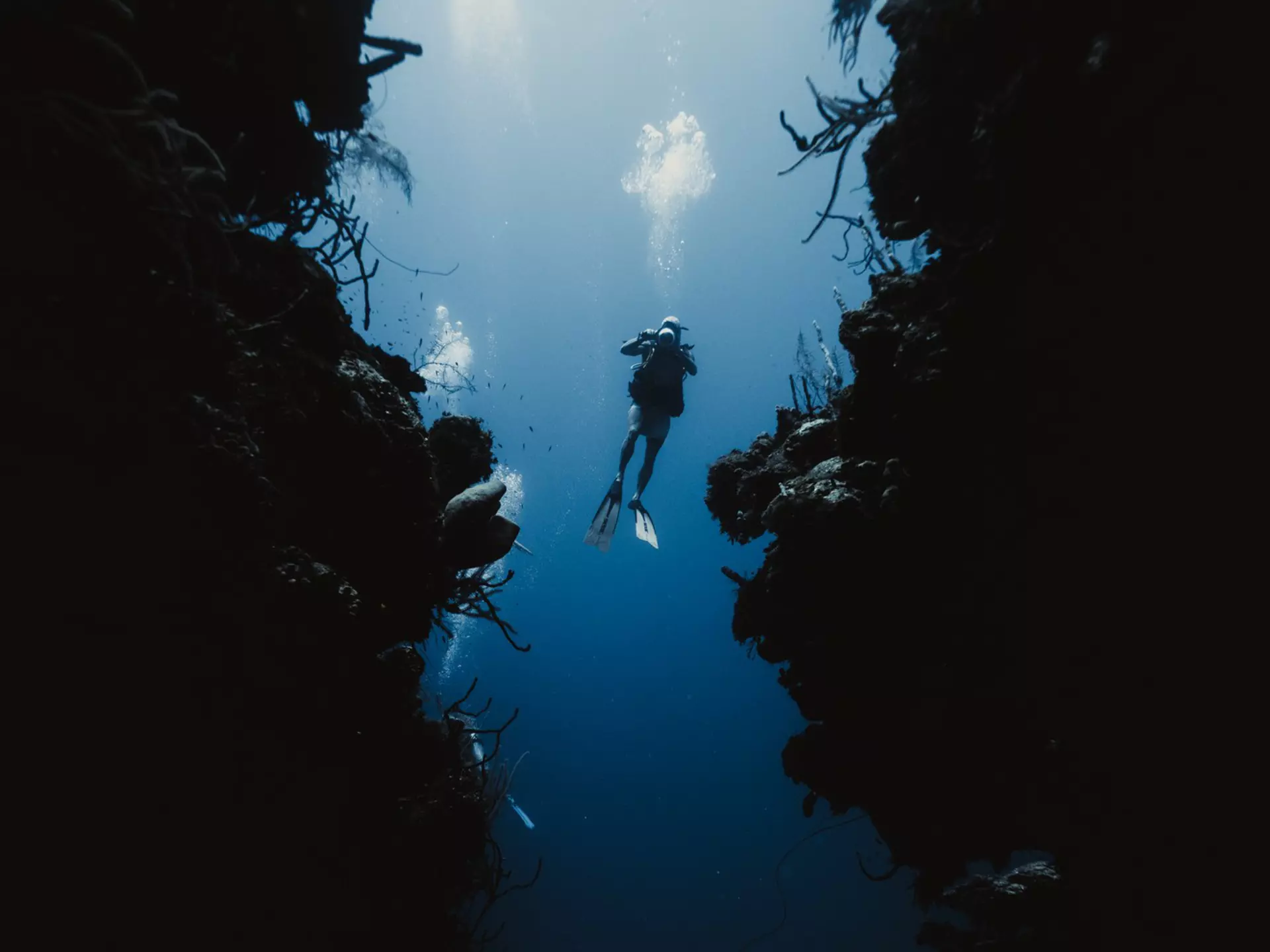 A solo scuba diver with excellent buoyancy hovers between walls in an underwater passage