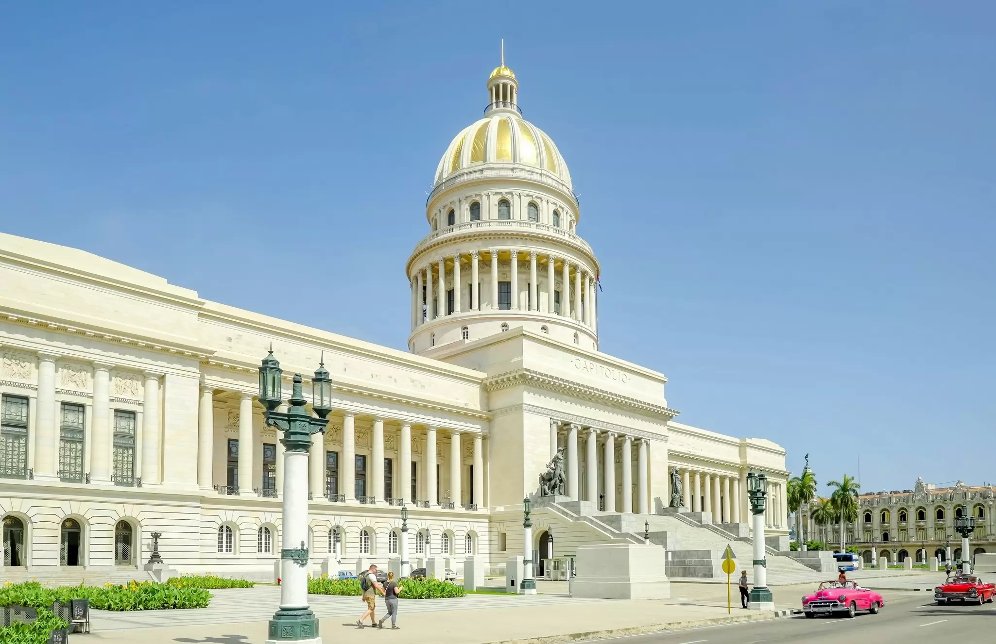 A shot of convertible cars driving past el Capitolio during an afternoon in old Havana, Cuba.