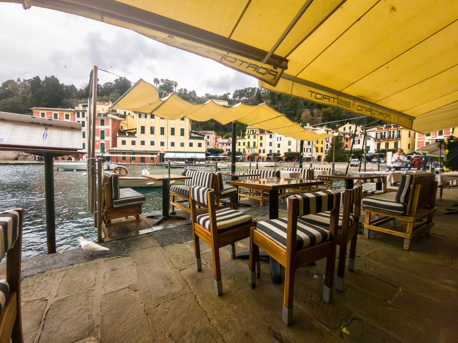 Portofino, Italie - 12-29-2023: the quays of Portofino's typical little port, with the terraces of the restaurants set up along the water's edge., License Type: media, Download Time: 2025-10-07T17:37:14.000Z, User: Sarahstocking, Editorial: true, purchase_order: 65050 - Digital Destinations and Articles, job: Digital, client: Guide to Portofino, other: Sarah Stocking