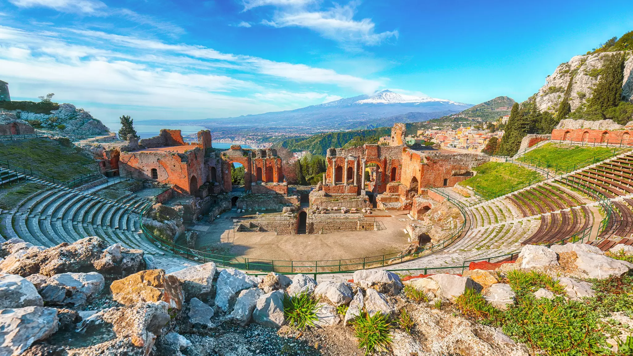 Ruins of ancient Greek theater in Taormina with Mt Etna beyond in Sicily, Italy. Vadym Lavra/Shutterstock