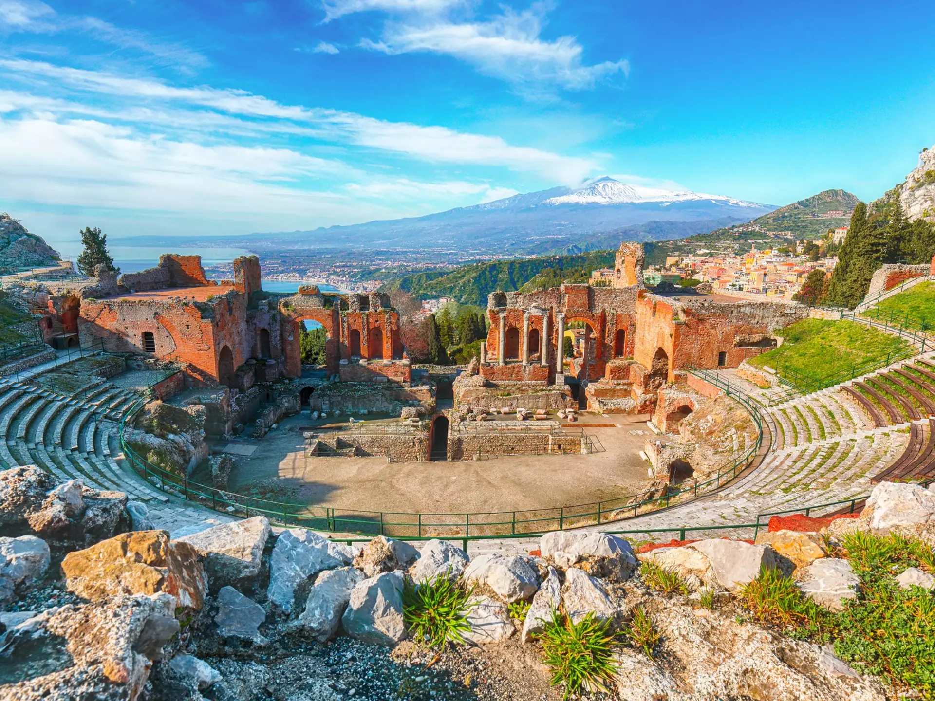 Ruins of ancient Greek theater in Taormina with Mt Etna beyond in Sicily, Italy. Vadym Lavra/Shutterstock