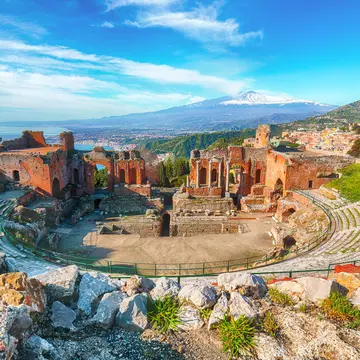Ruins of ancient Greek theater in Taormina with Mt Etna beyond in Sicily, Italy. Vadym Lavra/Shutterstock