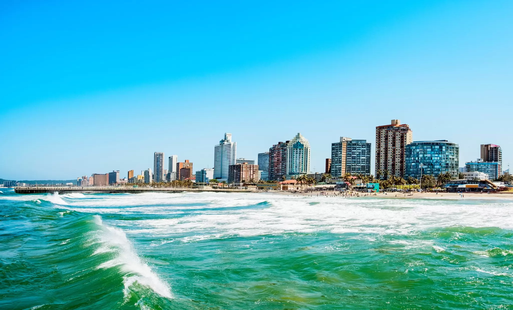 Sea waves with coastal high-rise in background, Durban.
924753218
Travel Destinations, Horizontal, Beach, Surf, Clear Sky, Blue, City Life, Nature, Urban Skyline, Cityscape, Architecture, Building Exterior, Motion, Built Structure, Waterfront, Tower, Wake, Durban, Photography, Sky, Shore, Skyscraper, Skyline, Beauty In Nature, Day, Outdoors, No People, City, Power in Nature, Sea, Water, Wake - Water, Scenics - Nature, Wave - Water, Color Image