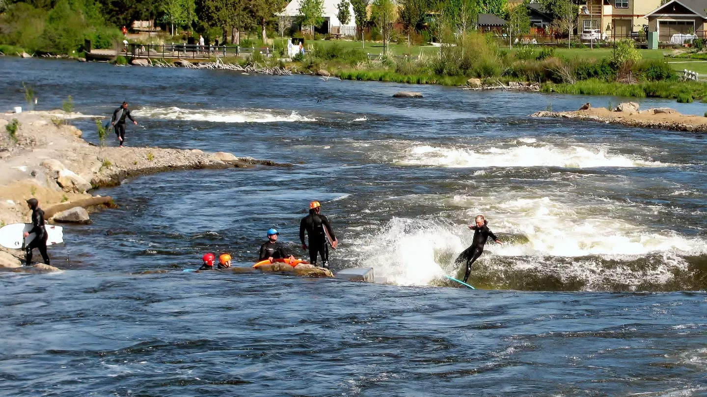 A group of people river surfs on the Deschutes River