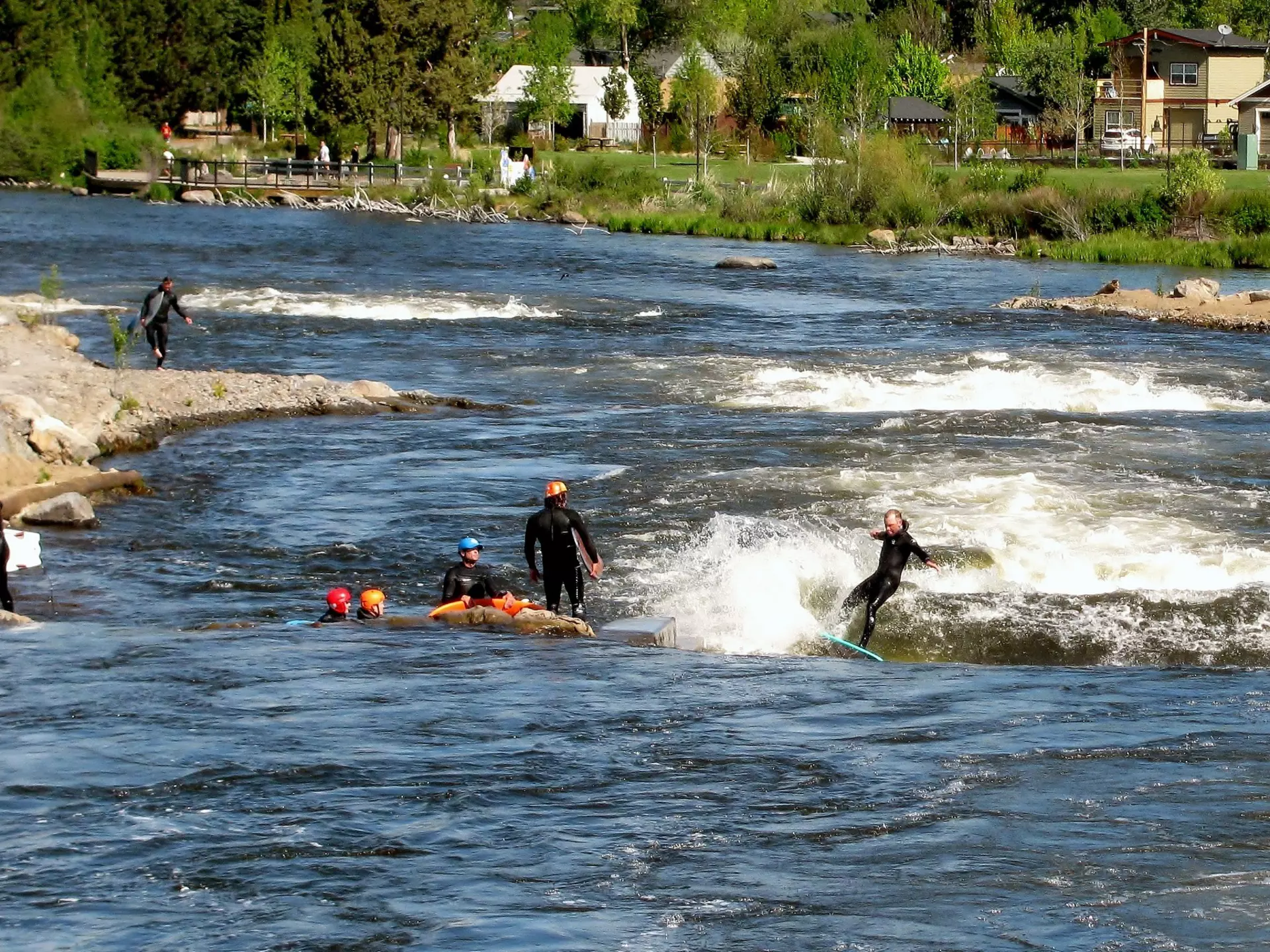 A group of people river surfs on the Deschutes River