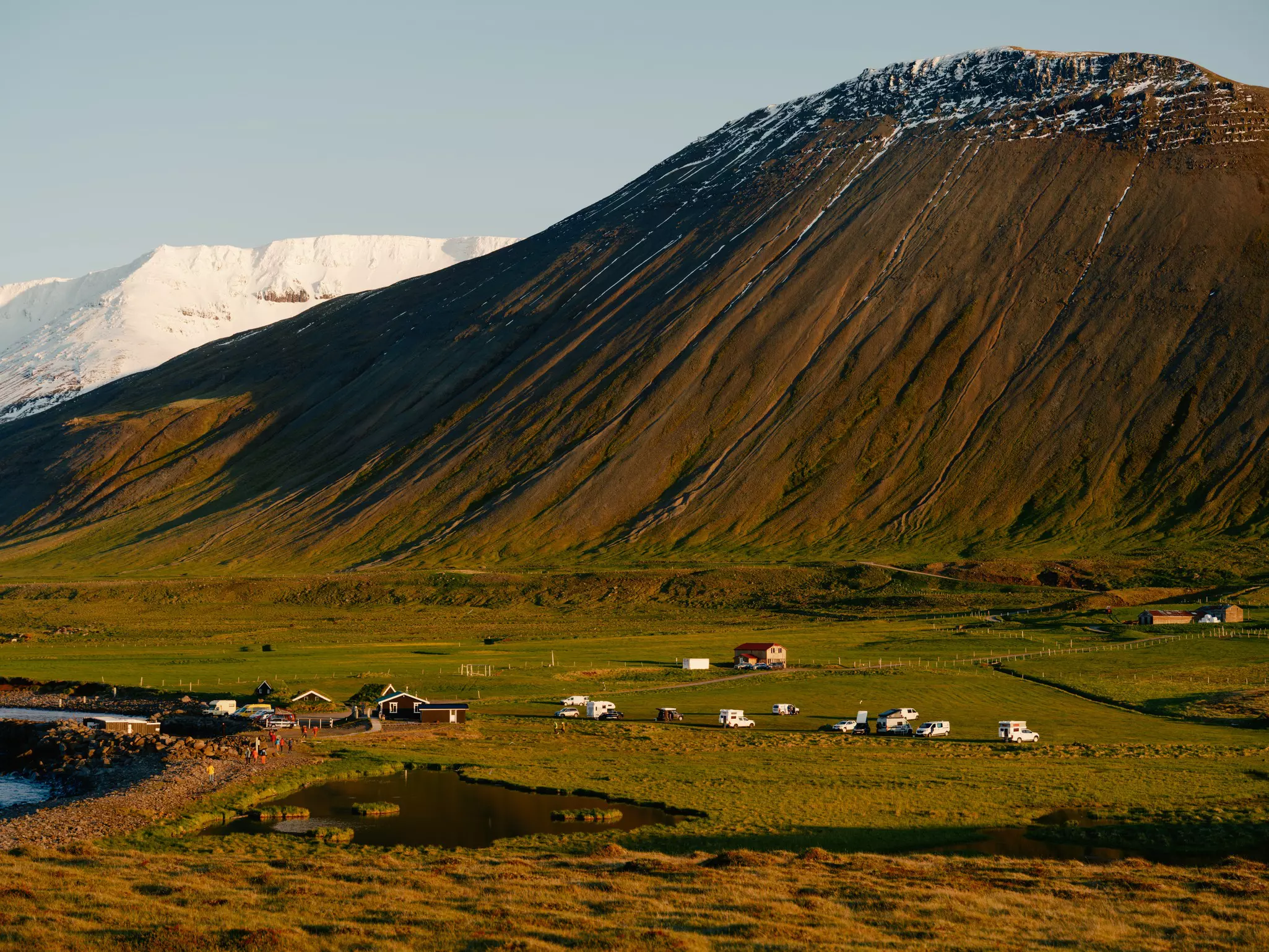 Mountains rise behind the Grettislaug campsite in Reykhólar, Iceland.