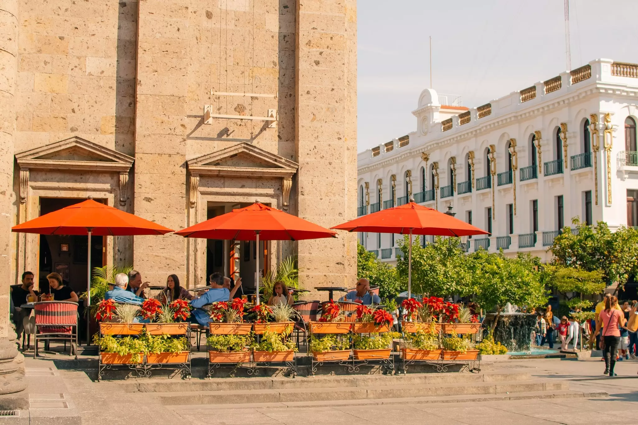 People drinking under umbrellas in a cafe on a square in Guadalajara, Mexico.