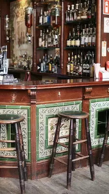 Two men dressed in white work behind an ornate bar