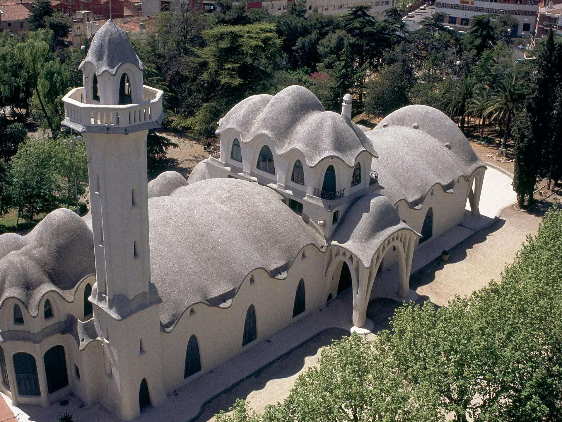 An aerial view of Masia Freixa in Terrassa, built in the Catalan Modernisme style. A white building with arches around its exterior. 
