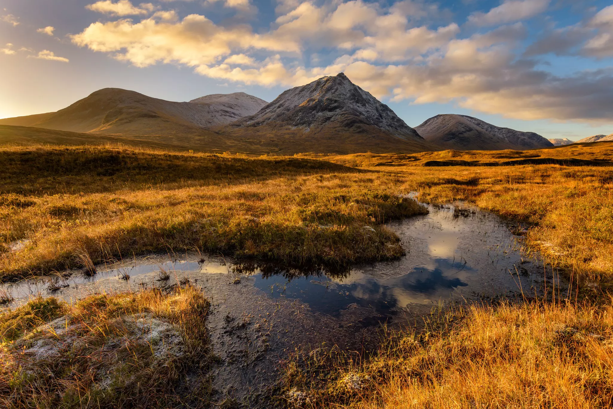Golden morning light at Rannoch Moor with snowcapped mountains. Scotland.