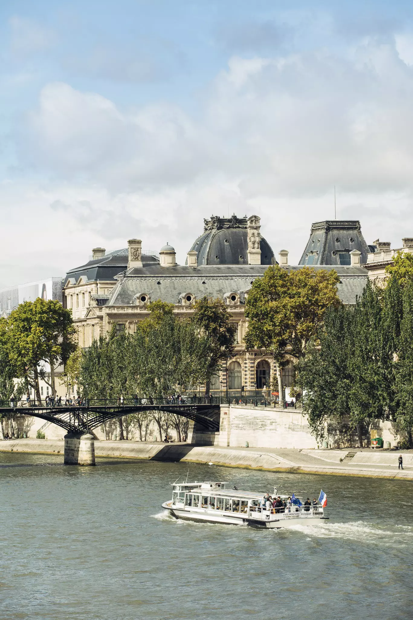 The pedestrian Pont des Arts crosses the River Seine, linking the Palais du Louvre (shown) and the Institut de France.