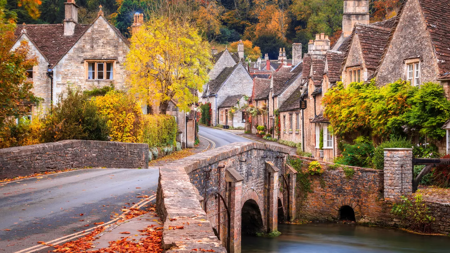 A stone bridge over Bybrook River in Castle Combe in autumn.
