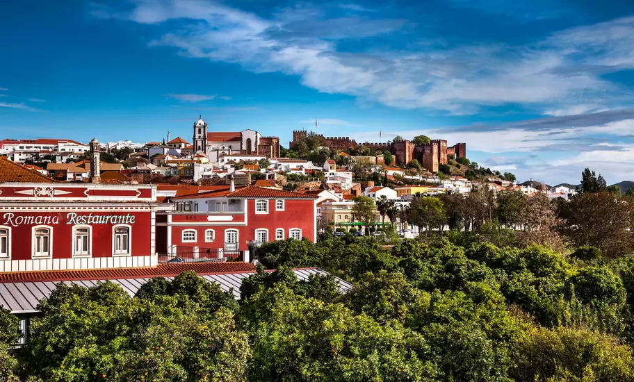 Silves, Algarve, Portugal, red sandstone castle and cathedral above whitewashed houses and orange groves