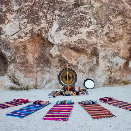 Colorful blankets arranged around a gong outdoors