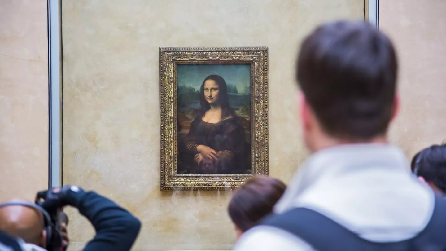 A crowd of people look at the Mona Lisa painting