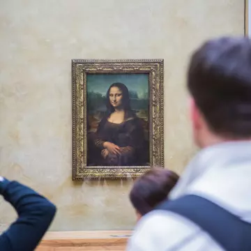 A crowd of people look at the Mona Lisa painting