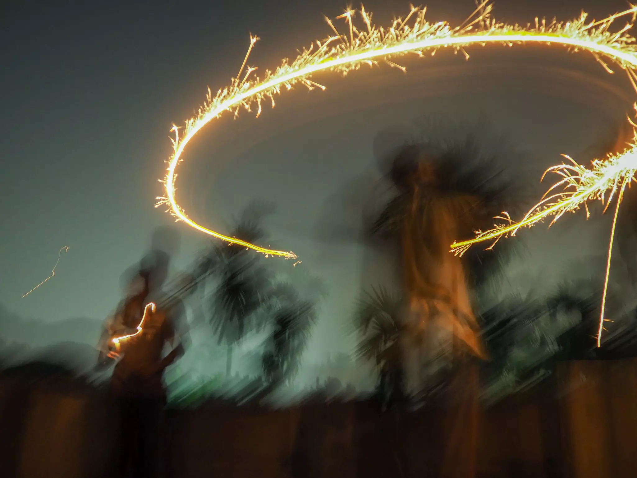 A blurred image of children playing with sparklers