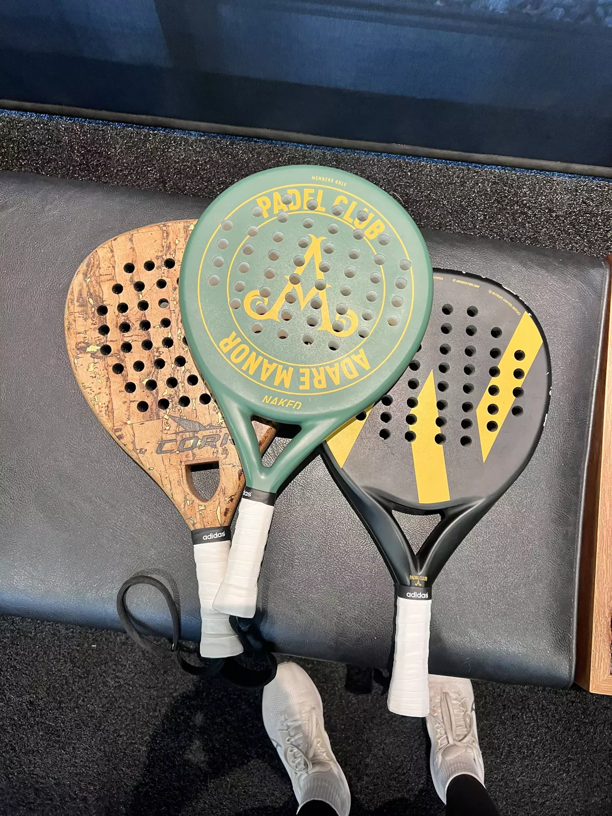 Three padel rackets on a seat.
