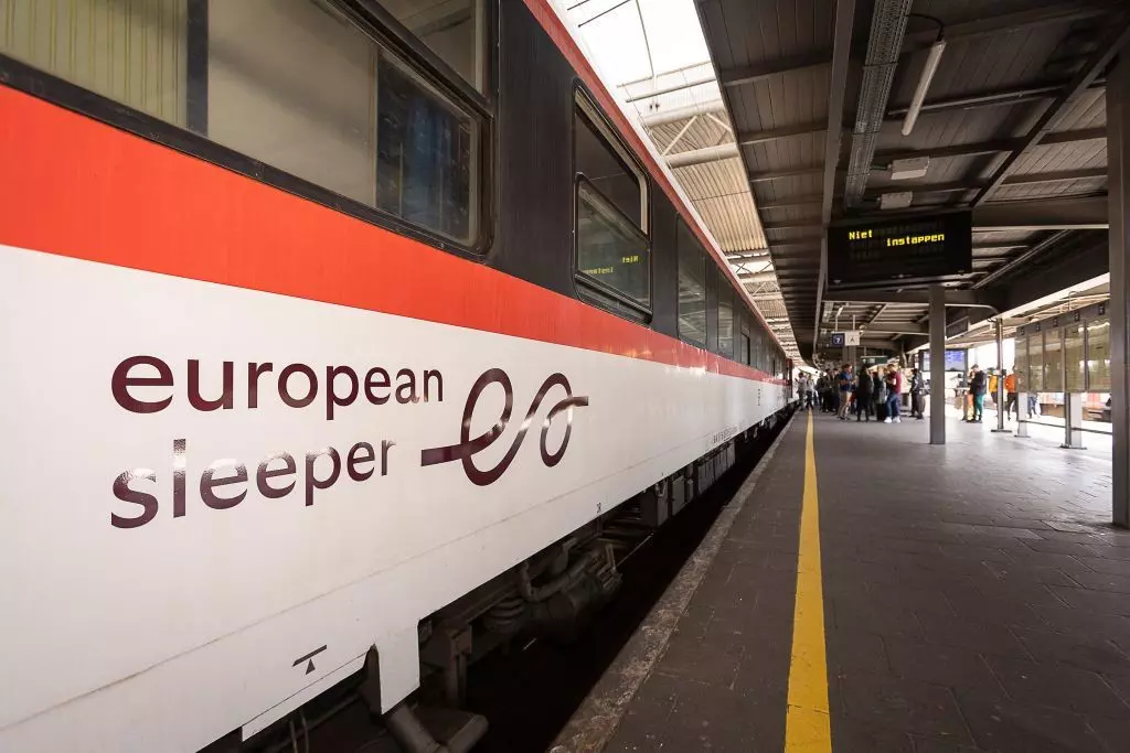 Close-up of white and red train in a station with the words "European Sleeper" on its side.
