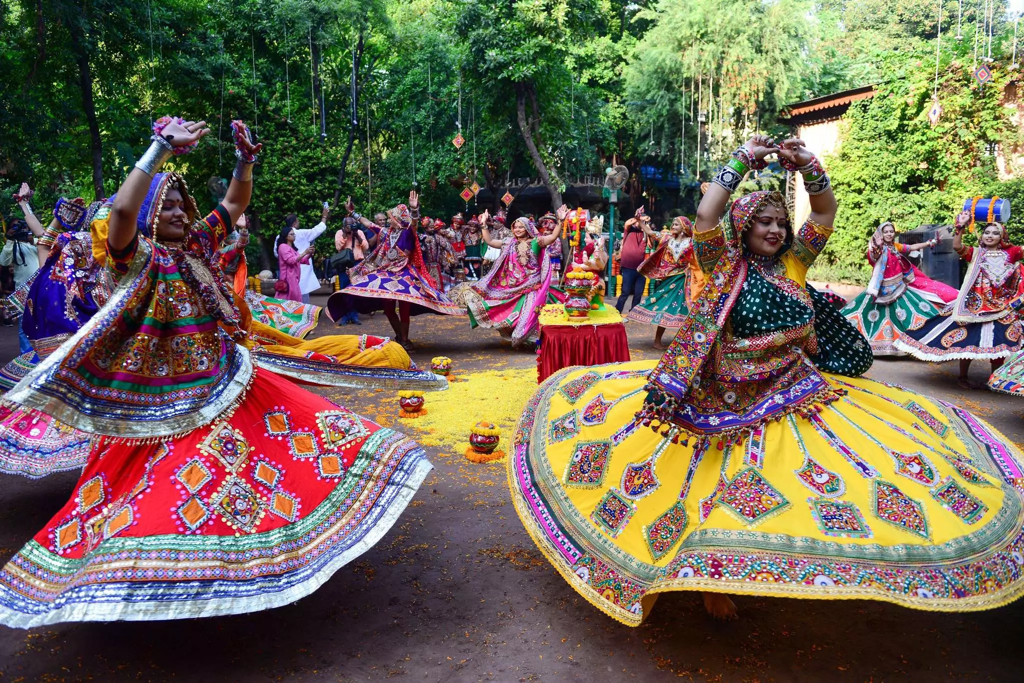 Women in elaborate skirts and draped in colorful fabrics spin during a dance for a traditional festival in India.