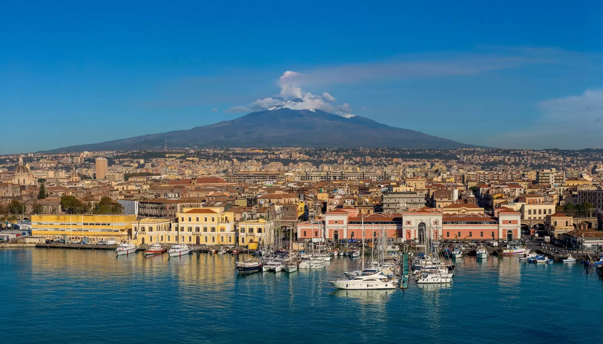 Mt Etna and the port of Catania, Sicily. Carlos Yudica/Shutterstock