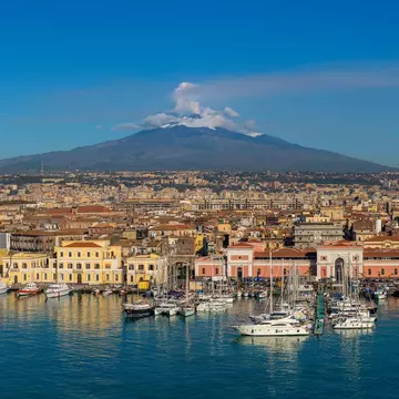 Mt Etna and the port of Catania, Sicily. Carlos Yudica/Shutterstock