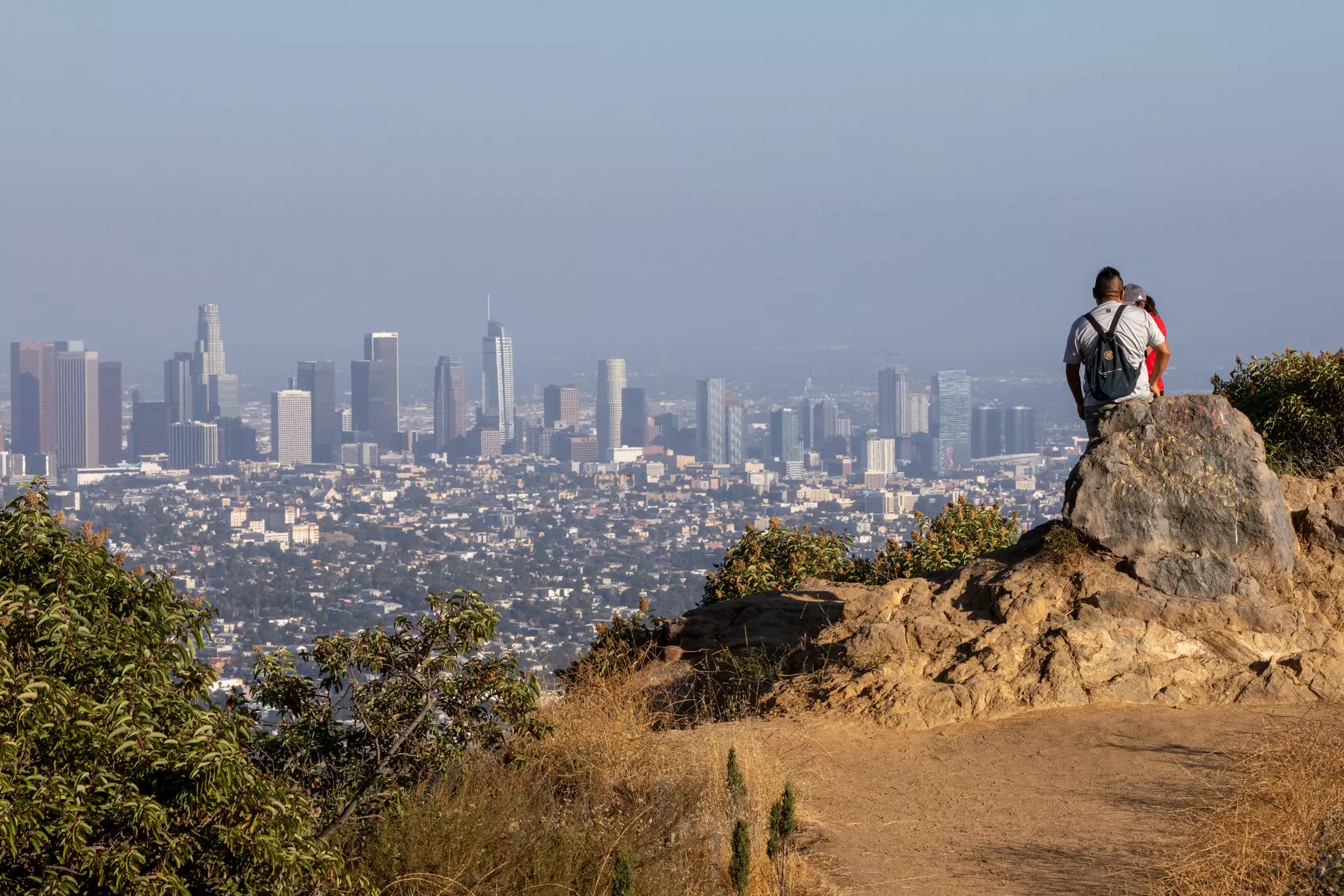 A couple looking at the landscape with Downtown LA from the Griffith Park Observatory Trails Peak