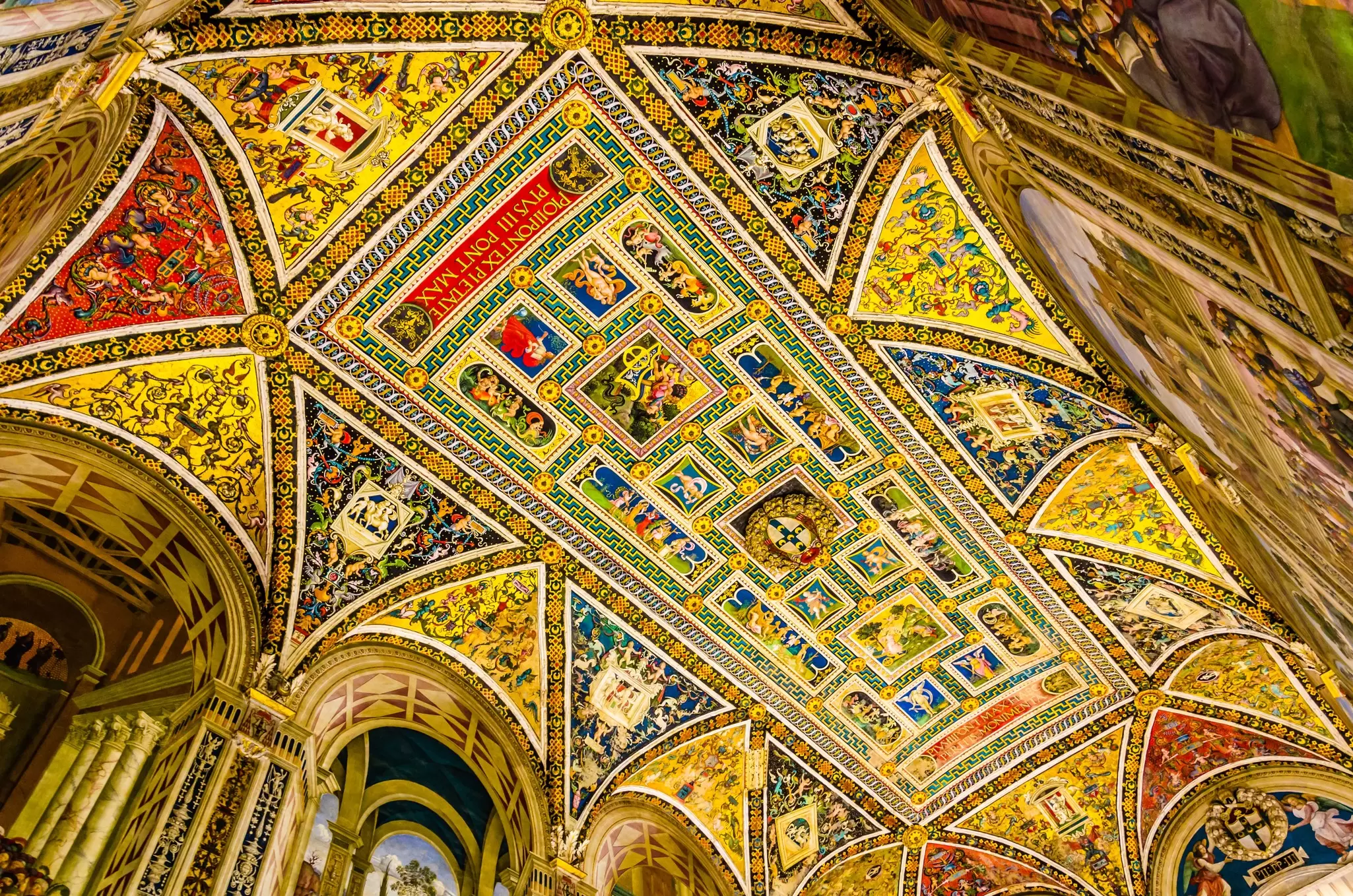 View of the ceiling of the colorful Piccolomini Library inside Siena Cathedral.