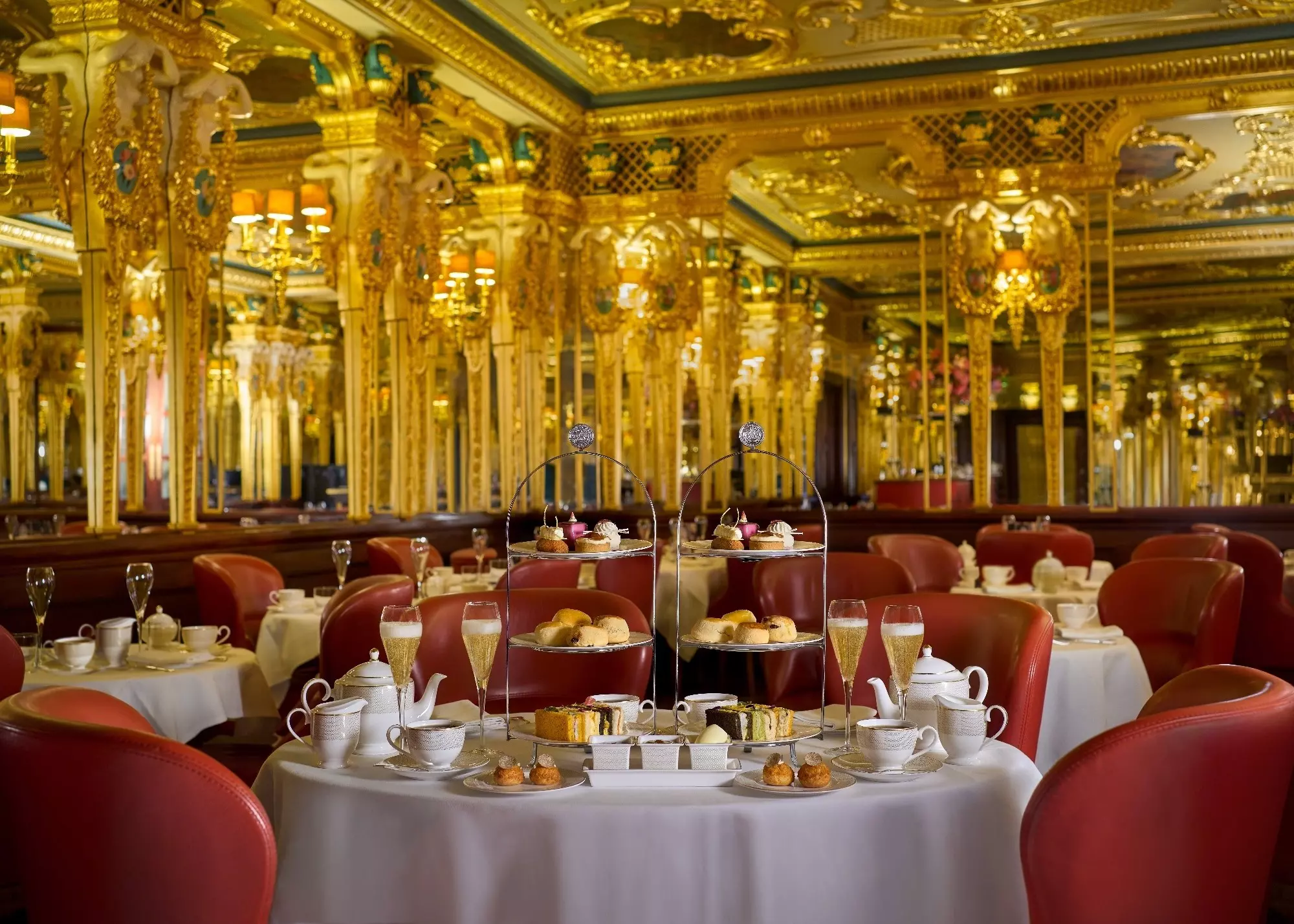 Afternoon tea with glasses of Champagne in a gilded London restaurant.