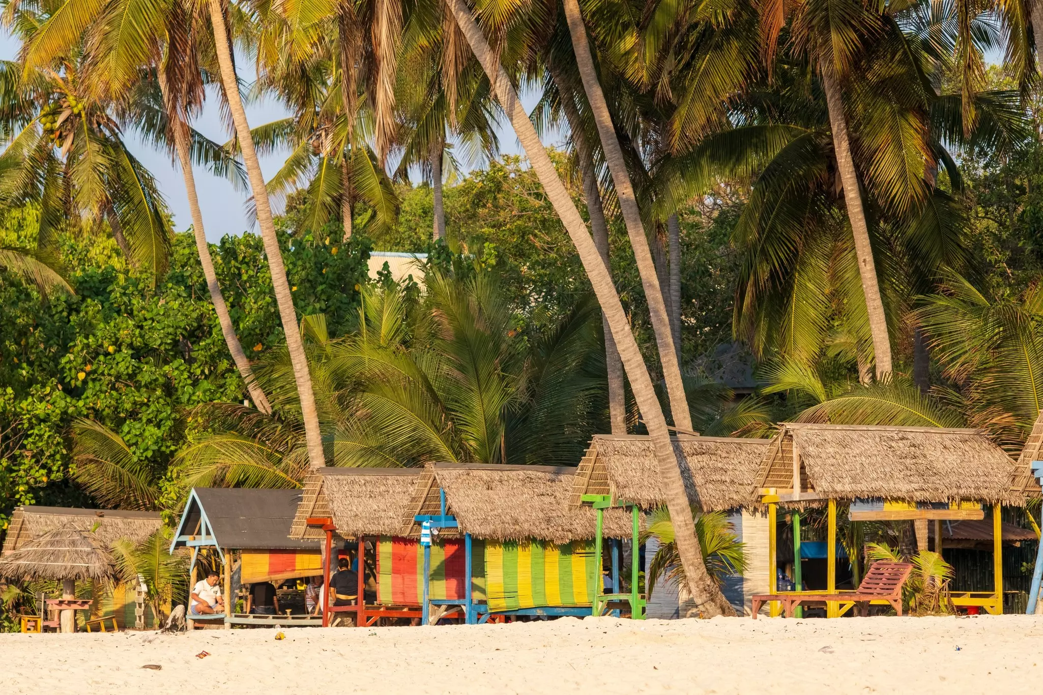 Huts on the beach under palm trees at Bira on Sulawesi, Indonesia.