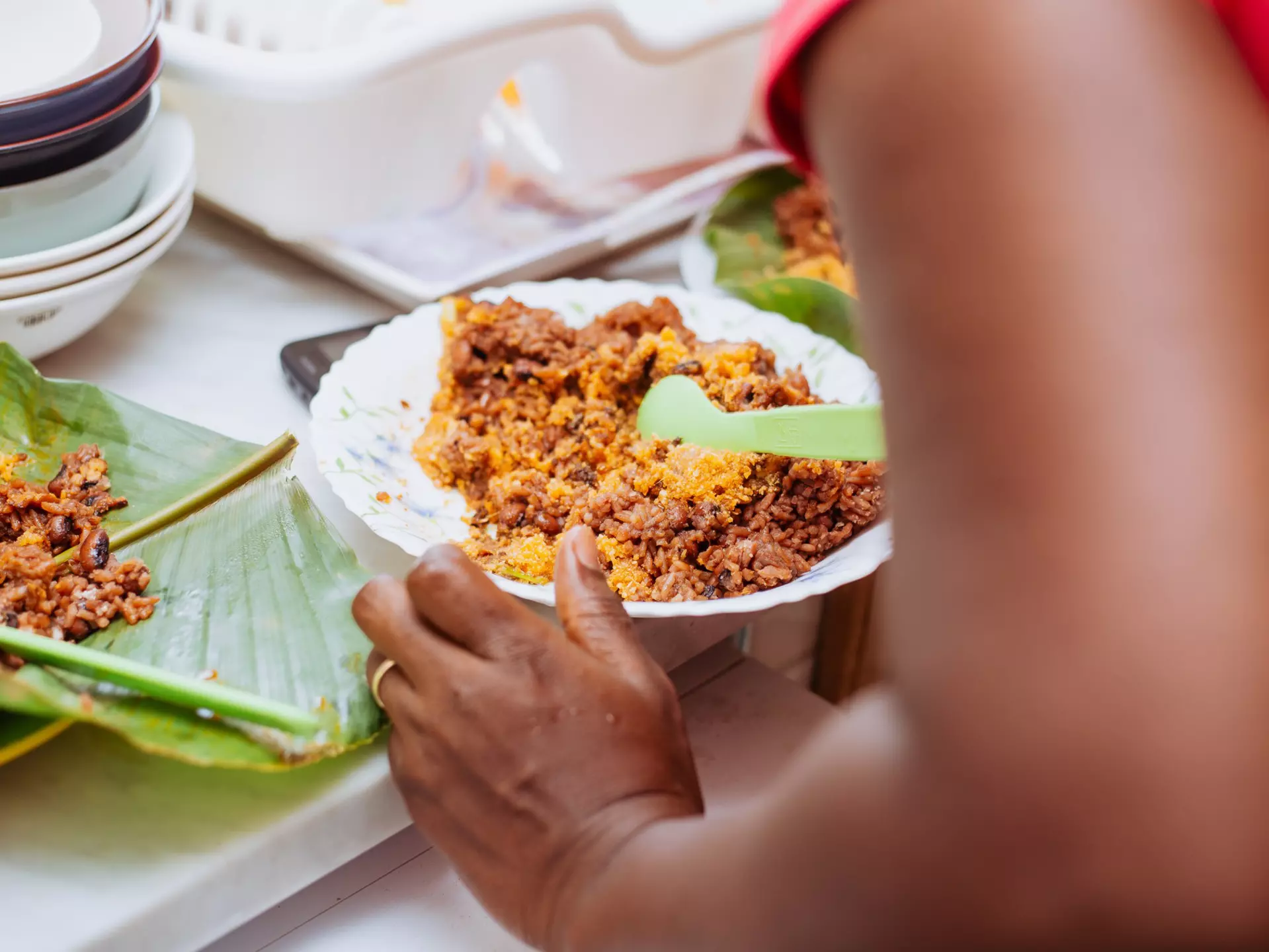 Cropped hands of woman having a plate of jollof rice at a table