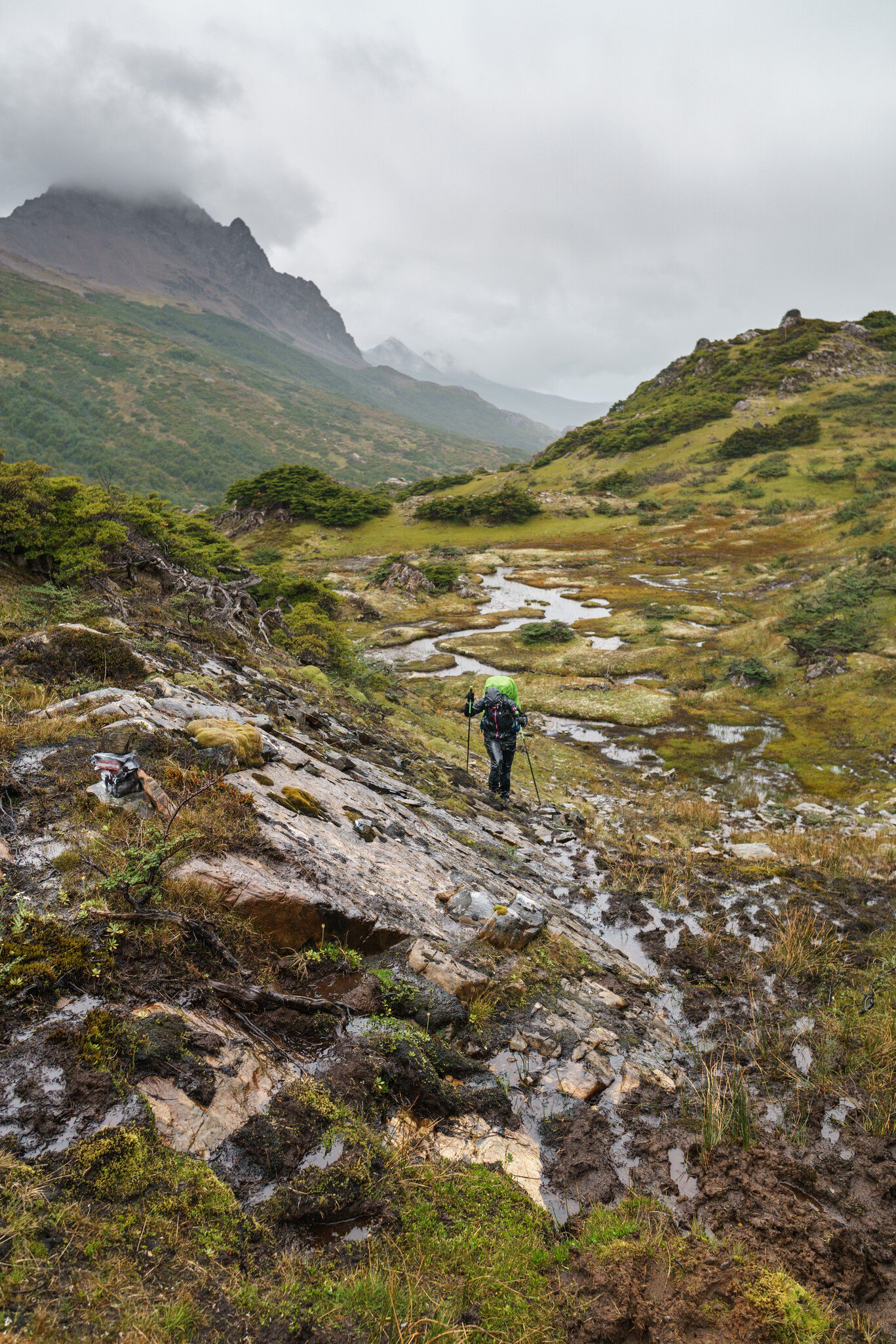 Hiker on the muddy trails of Dientes de Navarino during heavy rains, southernmost hike in the world, Isla Navarino, Chile.