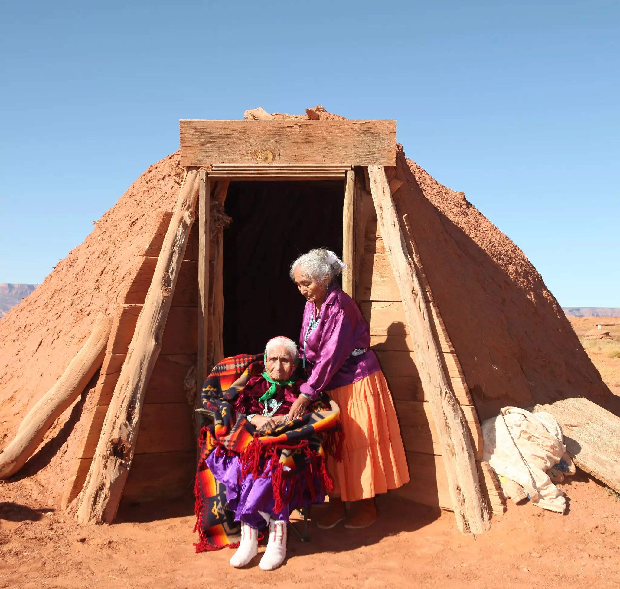 Family of 2 Navajo Women Outside Their Traditional Hogan Hut