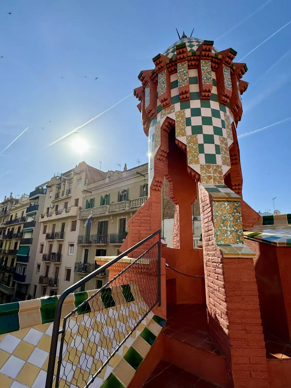 The building features colorful ceramic tiles, intricate brickwork, wrought iron details, and decorative elements inspired by nature.