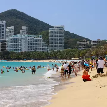 Sanya, China - February 23, 2025: Crowd of people tanning and swimming on sea beach in Dadonghai bay of Hainan island, License Type: media, Download Time: 2026-09-02T16:20:37.000Z, User: LP_NZhan, Editorial: true, purchase_order: 65050 - Digital Destinations and Articles, job: App Content, client: Lonely Planet App, other: Nadine Zhan