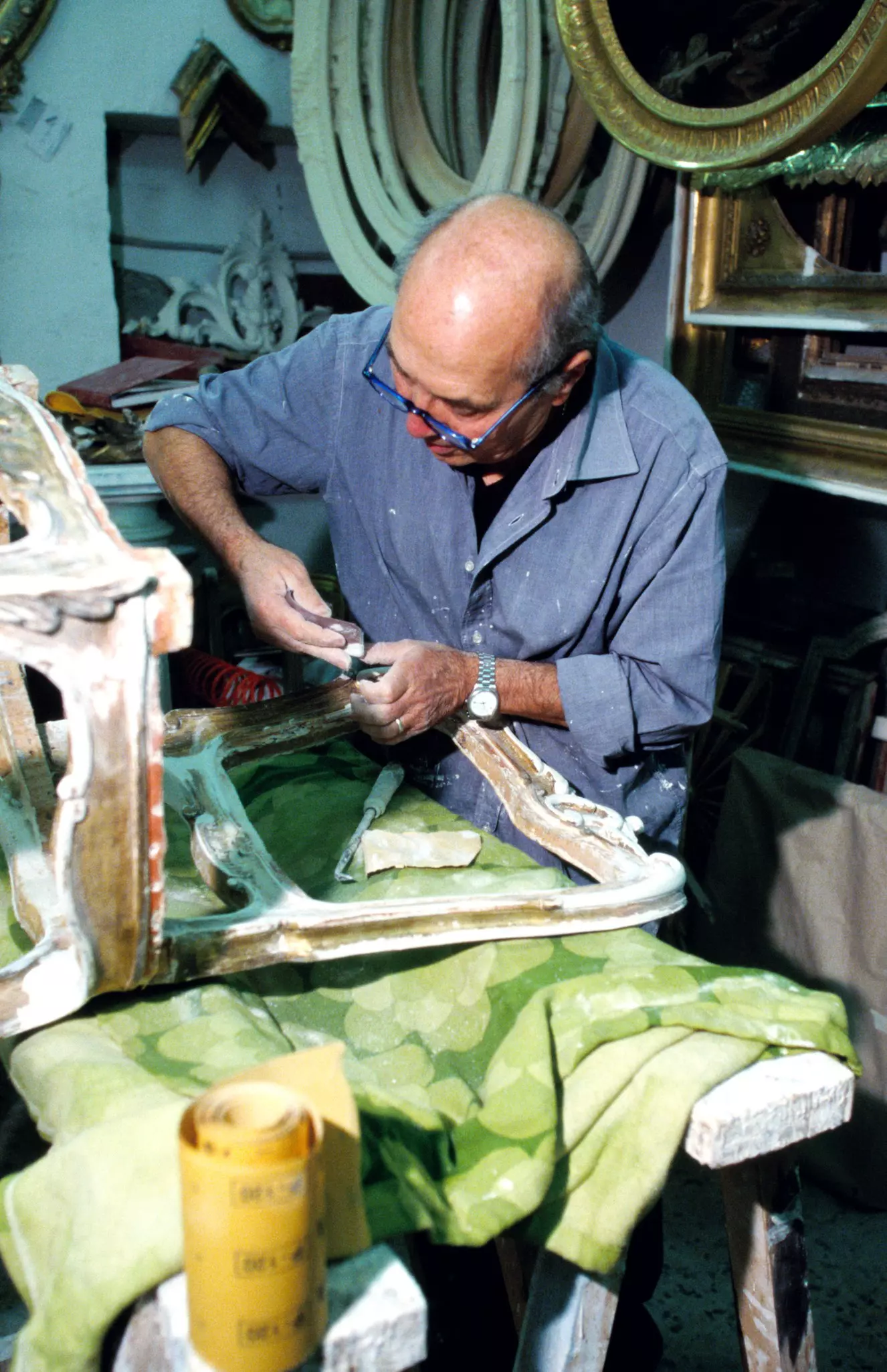 A man restores an antique chair in Via Costantinopoli, Naples, Italy.