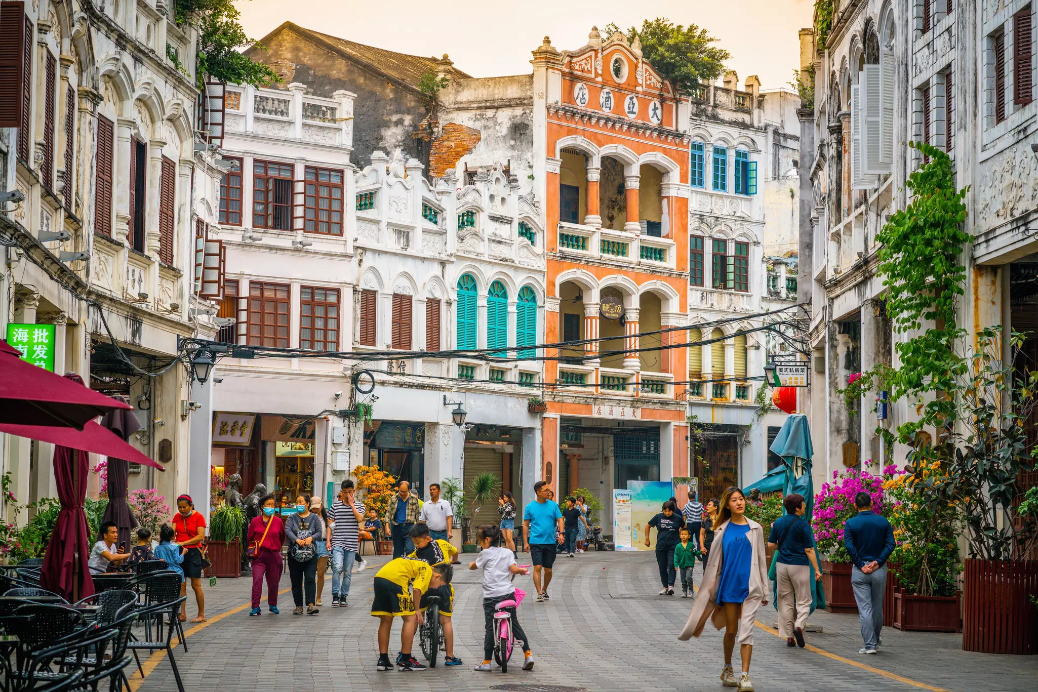 People walk past traditional qilou row-houses in Haikou, Hainan, China.