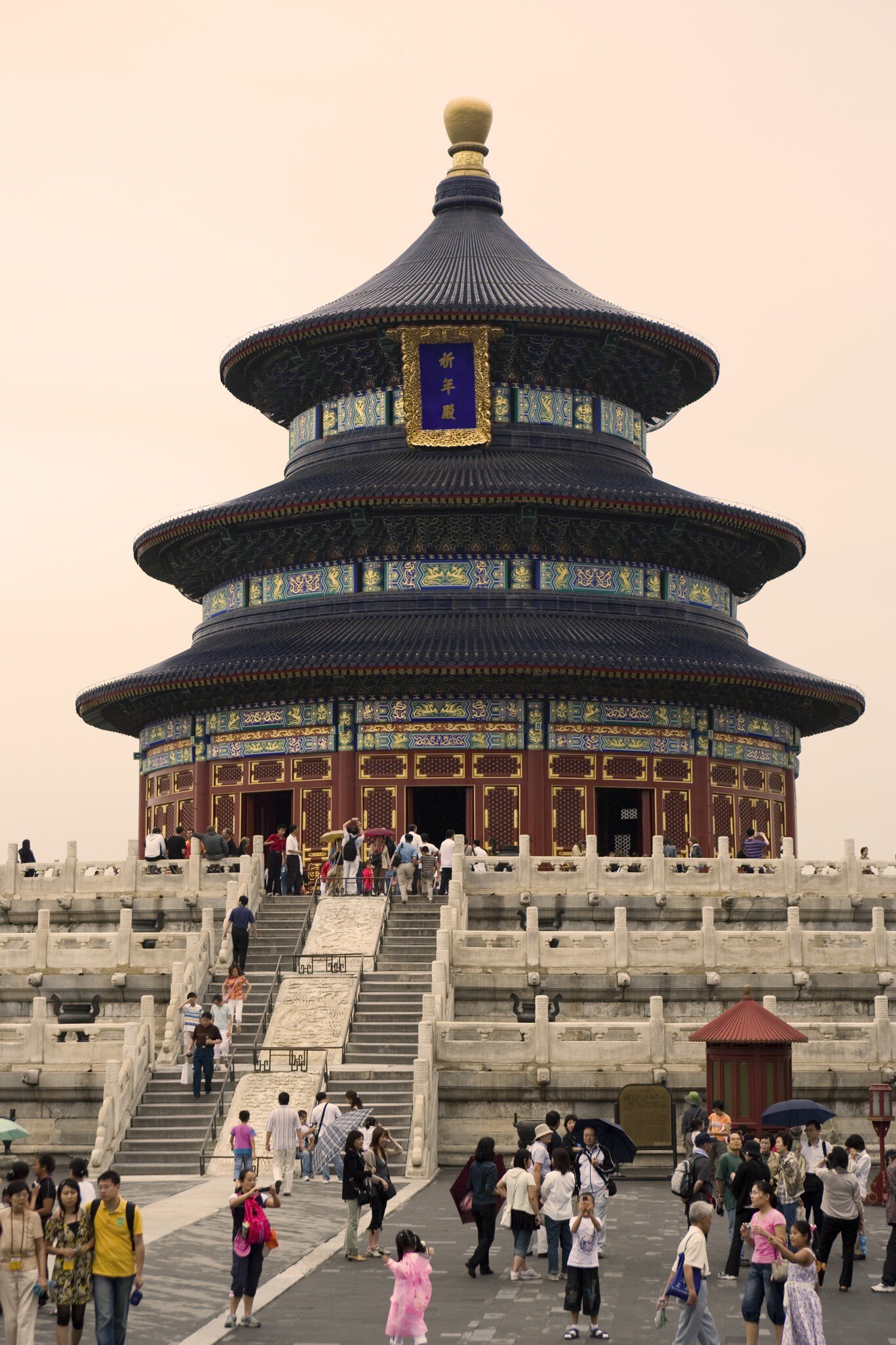 Round triple-roofed wooden hall with blue tiles on white marble terraces, crowds of visitors, Temple of Heaven, Beijing.
